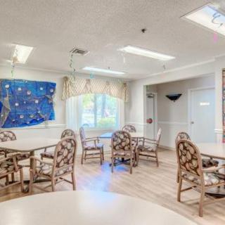 A bright and airy community dining area with tables and chairs set up for gatherings.