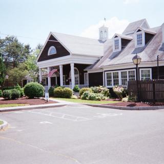A picturesque house with a garden and a spacious driveway.