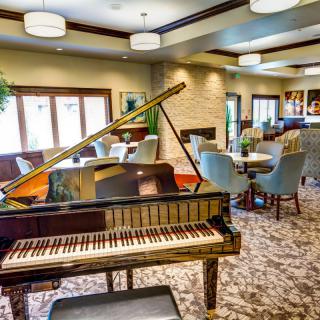 A cozy lounge area with a grand piano and elegant seating arrangements.
