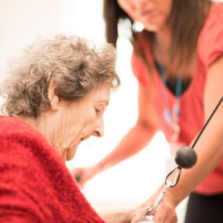 An elderly person receiving assistance from a caregiver.
