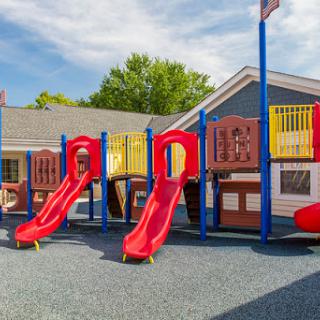 A vibrant playground featuring red slides and colorful play structures, perfect for outdoor fun.