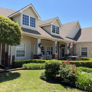 A picturesque suburban house with a well-maintained lawn and garden.