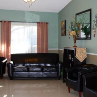 A cozy living room with dark leather seating and decorative accents.