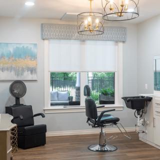 A modern hair salon interior with stylish lighting and a comfortable hairdressing setup.