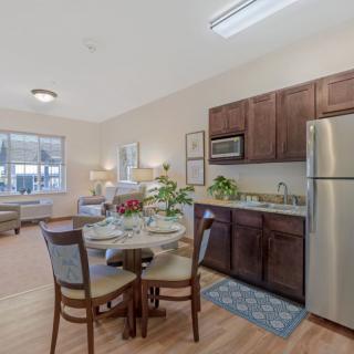 A modern apartment featuring a cozy kitchen and dining area with contemporary furniture and bright lighting.