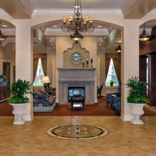 A beautifully designed lobby featuring elegant furnishings, decorative plants, and a cozy fireplace.