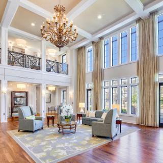 A beautifully designed living room featuring a stunning chandelier and ample natural light.