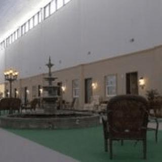 An indoor space featuring a fountain surrounded by seating and warm lighting.
