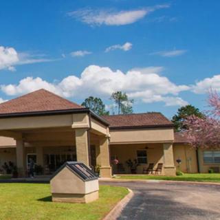 A building entrance with a driveway and cloudy sky.