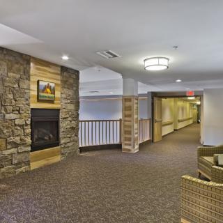 A cozy hallway with a stone fireplace and seating area.