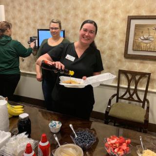 A cheerful gathering with someone serving snacks.