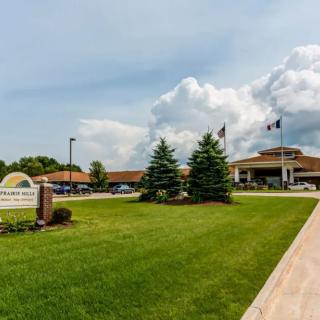 A hospital with a well-maintained lawn and a cloudy sky in the background.