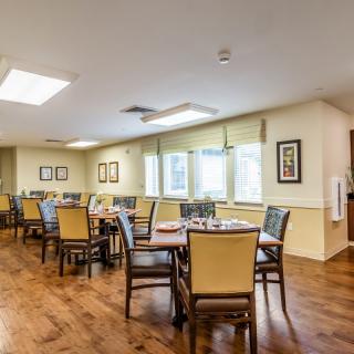 A well-lit dining area with neatly arranged tables and chairs.