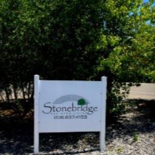 A sign for Stonebridge Community surrounded by greenery.