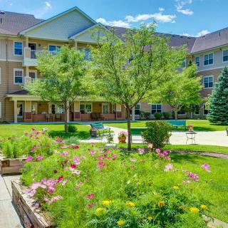 A sunny day at an apartment complex with a beautifully landscaped garden and courtyard.