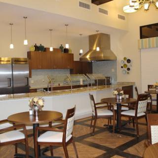 A modern dining area featuring an open kitchen and elegantly arranged tables.