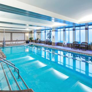 A serene indoor swimming pool area featuring modern design and ample natural light.