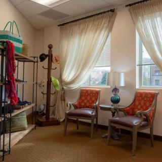 A cozy waiting room with two chairs, a small table, and natural light coming through the windows.