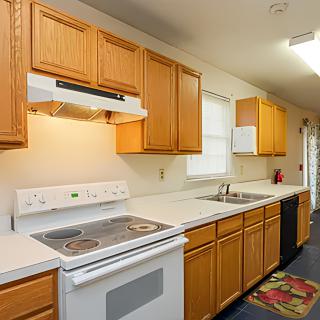 A modern kitchen with wooden cabinets, an oven, and a sink.