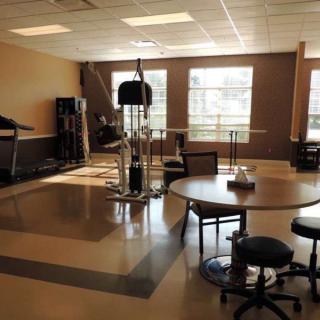 A rehabilitation room equipped with exercise machines and seating areas.