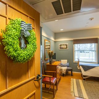 A cozy waiting room with a wreath on the door and comfortable seating.