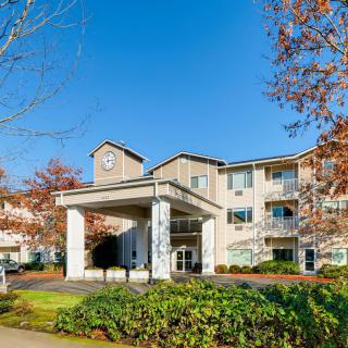 A view of a retirement home with a prominent entrance and well-maintained landscaping.