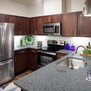 A modern kitchen featuring stainless steel appliances and dark wood cabinets.