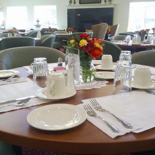 A neatly set dining table with flowers in a restaurant.
