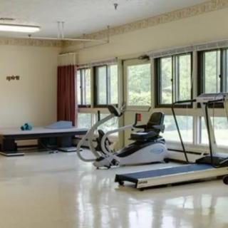 A gym with exercise equipment including a treadmill and stationary bike.