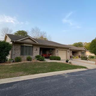 A charming single-story house with well-maintained landscaping.