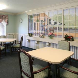 A cozy dining room featuring tables and chairs with a large wall mural.