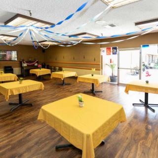 A well-decorated restaurant interior with tables covered in yellow tablecloths.
