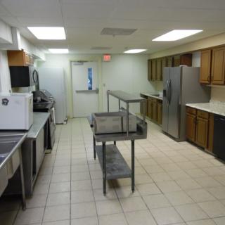 A clean commercial kitchen with stainless steel appliances and a central island.