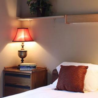 A cozy bedroom setting with a warm-lit lamp and a neatly arranged nightstand.