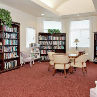 A cozy library reading area with bookshelves and comfortable seating.