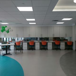 A modern office workspace featuring multiple desks and ergonomic chairs in a bright, open environment.