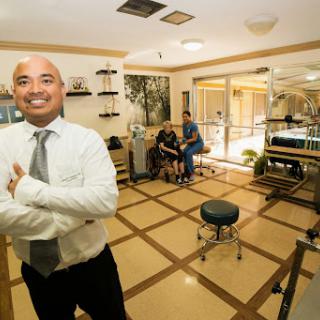 A smiling professional poses confidently in a well-lit office space.