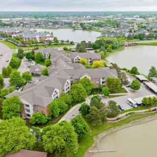 Aerial view of a residential area featuring apartments surrounded by greenery and multiple lakes.