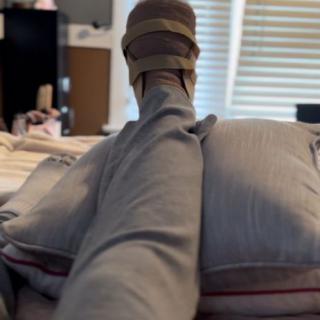 A leg in a cast resting on pillows indoors.