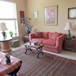 A cozy living room with a red sofa, coffee table, and decorative elements.