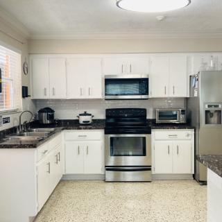 A modern kitchen with white cabinets and stainless steel appliances.