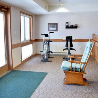 A small indoor exercise area with a stationary bike and a chair.