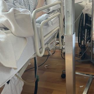 A close-up view of a hospital bed and surrounding medical equipment.