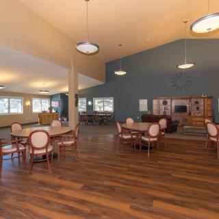 A spacious dining area with wooden floors and elegant furniture.