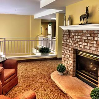 A cozy living room featuring a brick fireplace, plush armchairs, and warm lighting.