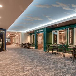 A modern restaurant interior with a sky-themed ceiling and seating area.