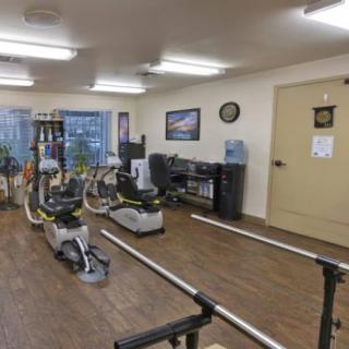 A fitness room equipped with various exercise machines and rehabilitation equipment.