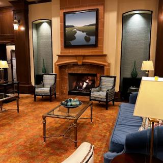 A cozy living room setting featuring elegant furniture, a warm fireplace, and beautiful artwork.