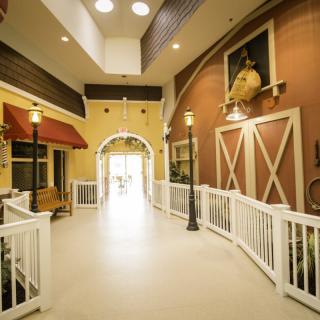 A barn-themed indoor hallway with rustic decor and warm lighting.