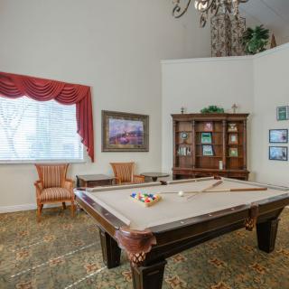 A cozy game room featuring a pool table, elegant furniture, and artwork on the walls.